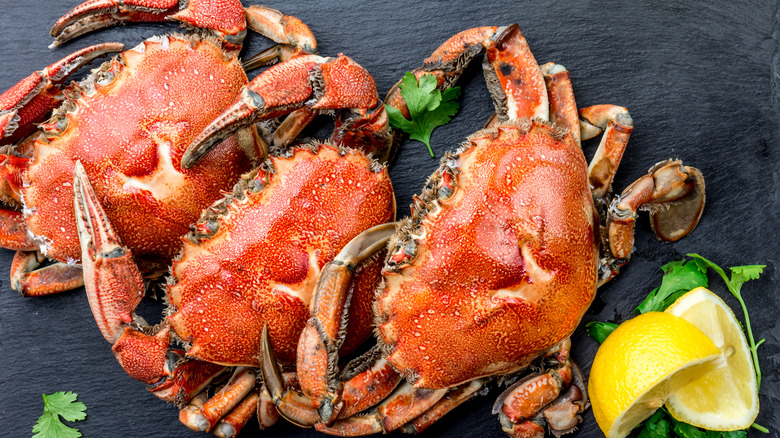 whole crab with lemon wedges