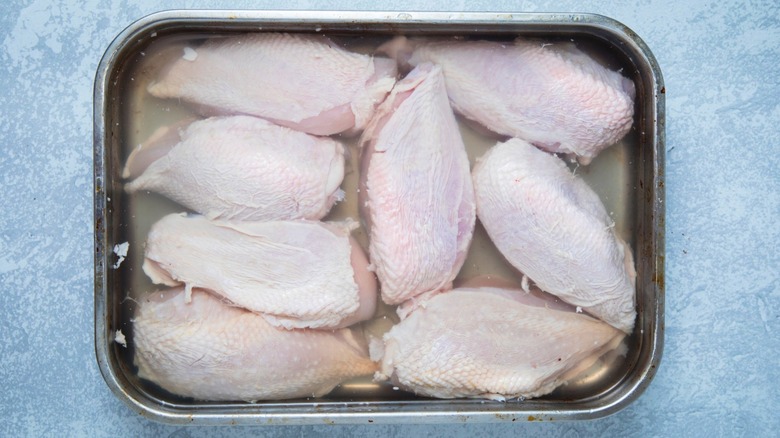 Raw chicken in clear liquid.