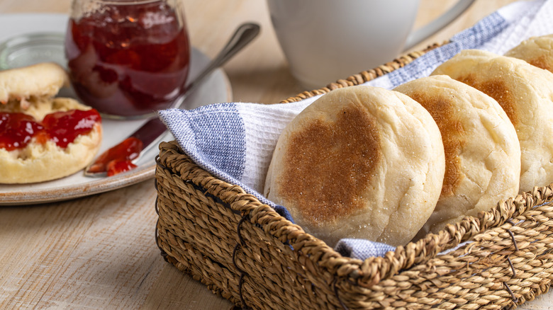 Basket of English muffins next to jar of jam
