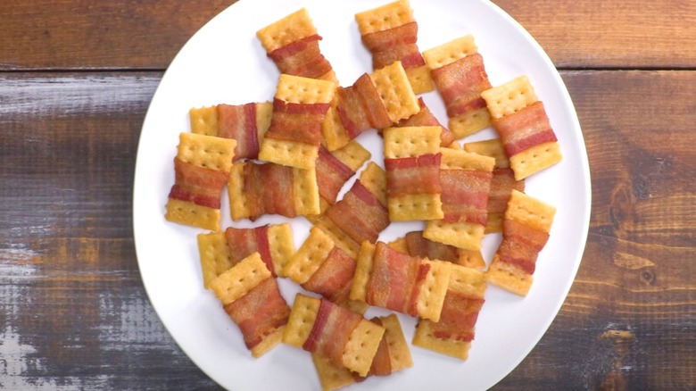 Bacon-wrapped crackers on white plate