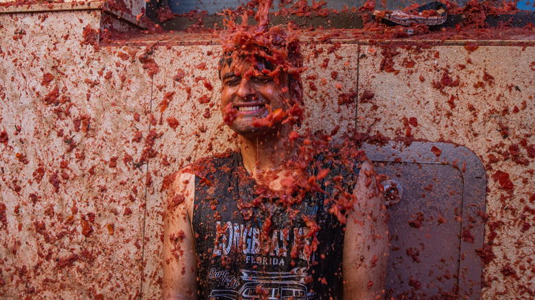 Person splattered with tomatoes at La Tomatina