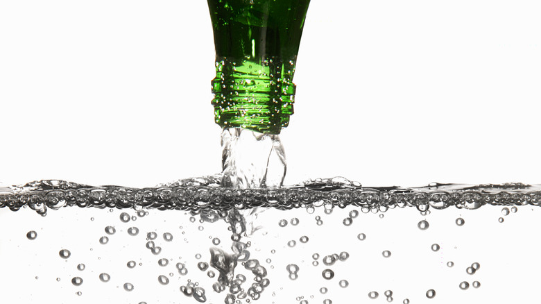 Green bottle pouring bubbly water