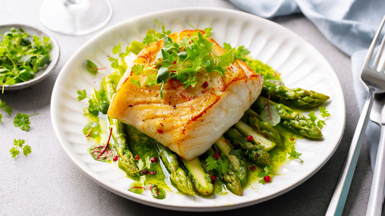 Fish plated atop asparagus