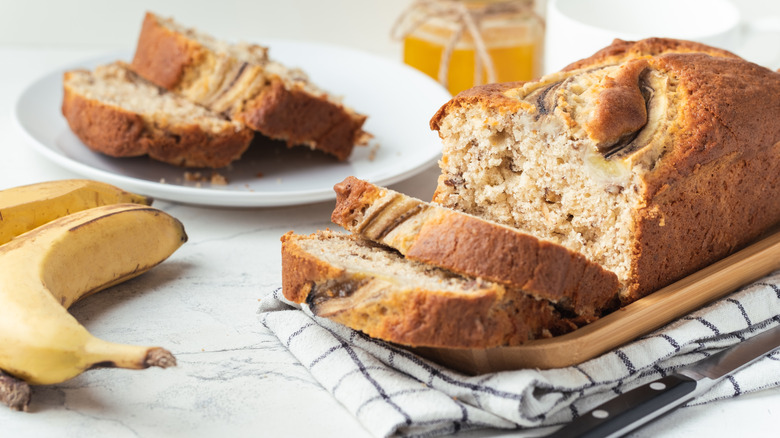 banana bread loaf sliced next to bananas