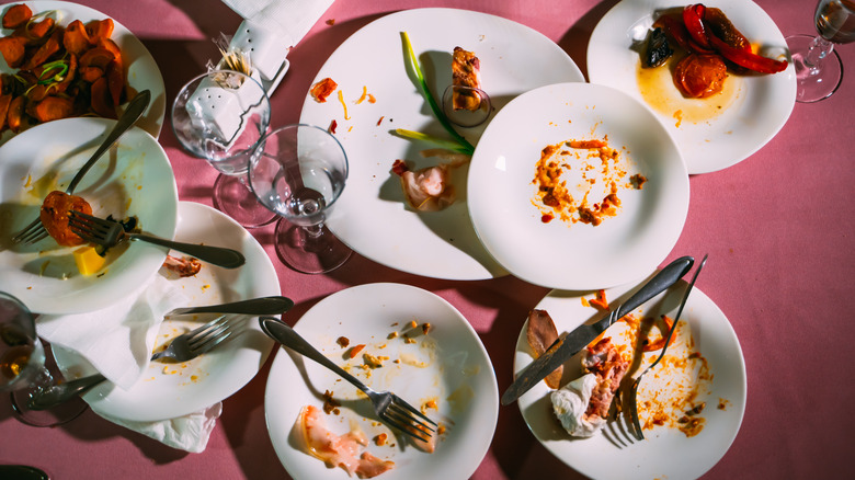 dirty restaurant plates on pink table