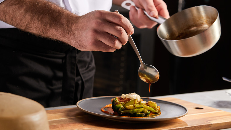 Chef plating taco with sauce