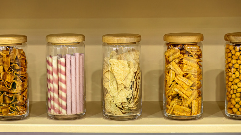 Different snacks in glass jars in a pantry