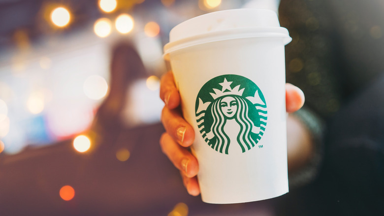 person holding a starbucks cup in a starbucks shop