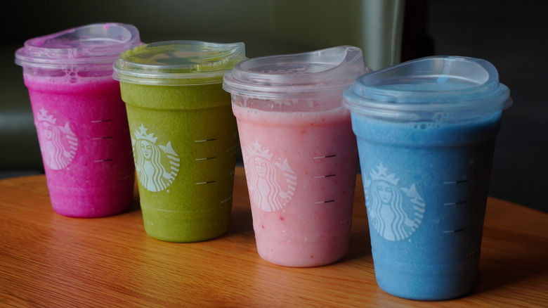 Side view of Starbucks' Blended Mango Dragonfruit Lemonade, Blended Matcha Lemonade, Blended Pink Drink, and Blended Ocean Drink (left to right).