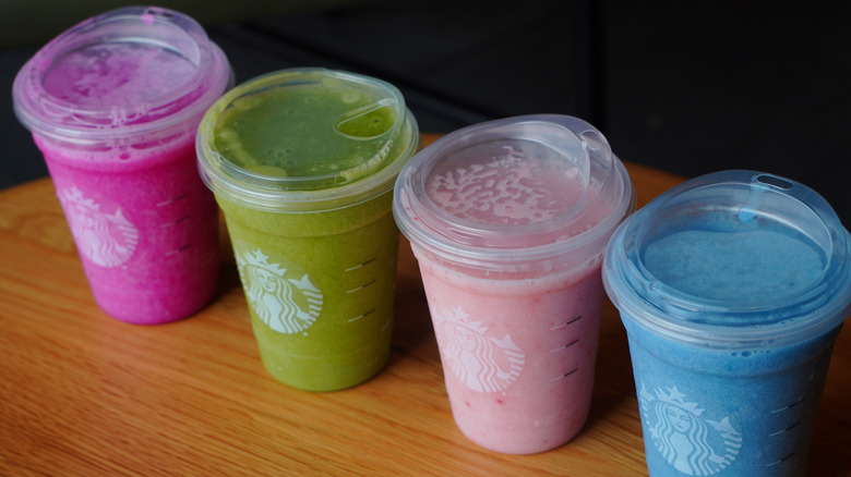 Top view of Starbucks' Blended Mango Dragonfruit Lemonade, Blended Matcha Lemonade, Blended Pink Drink, and Blended Ocean Drink (left to right).