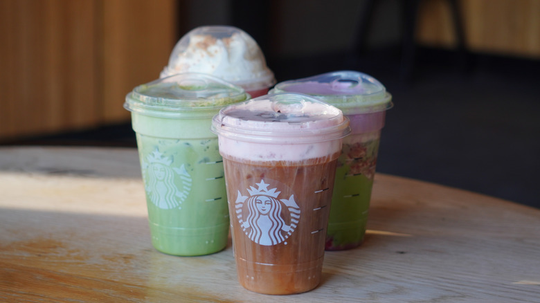 Side angle of Starbucks White Chocolate Strawberry Cream Cold Brew, Iced Banana Bread Matcha, Iced Double Berry Matcha, and Strawberry Shortcake Frappuccino