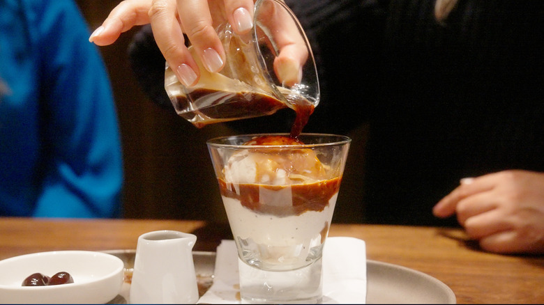 Hand pouring Starbucks Hot Honey Affogato