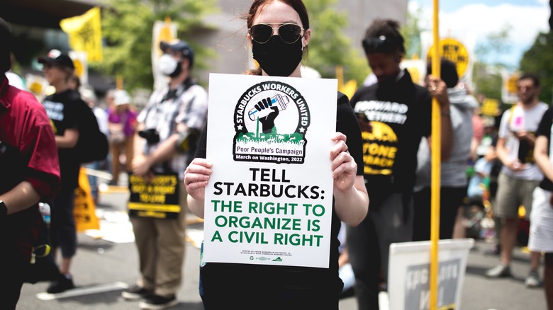 Masked Starbucks protestors holding signs