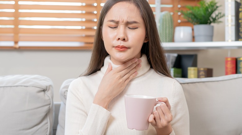 Woman with sore throat drinking tea