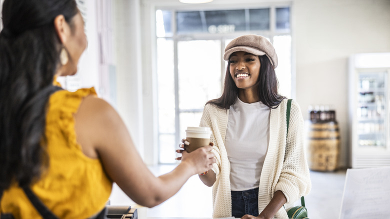 woman purchasing a cup of coffee to go