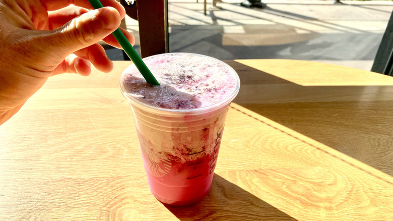 Stirring Starbucks Glinda's Pink Potion with straw
