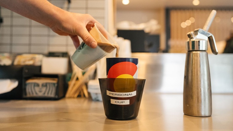 Starbucks pouring a drink into a personal cup