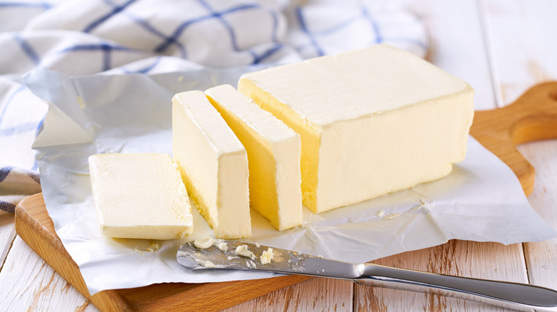 A sliced stick of butter next to a butter knife