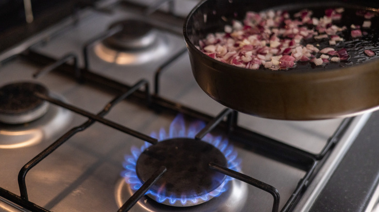 Pan of diced red onion over burner