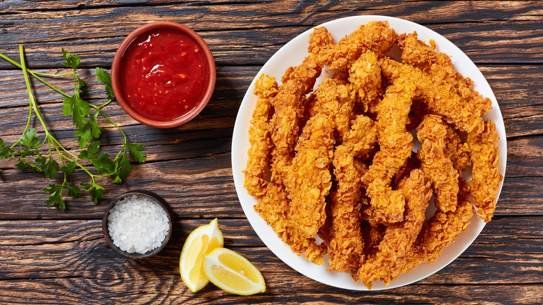 Cooked chicken pieces breaded in corn flakes
