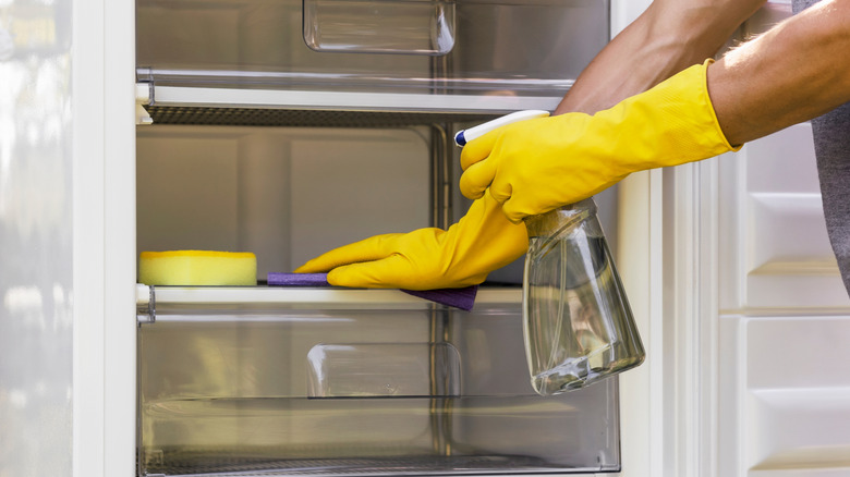 A person cleaning their refrigerator.