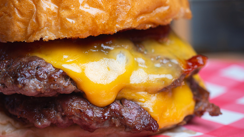 Closeup of a cheeseburger on checkered paper