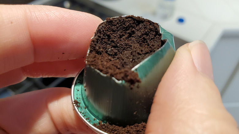 Close up photo of an open, used coffee pod exposing the grounds inside