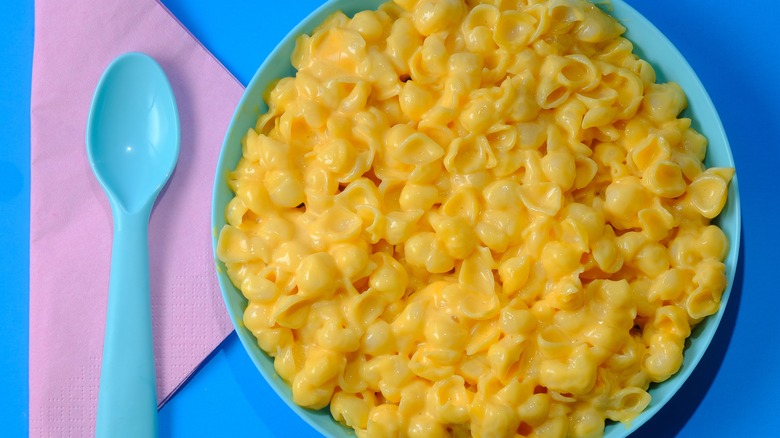 Blue plate of boxed shells and cheese with plastic kid's fork