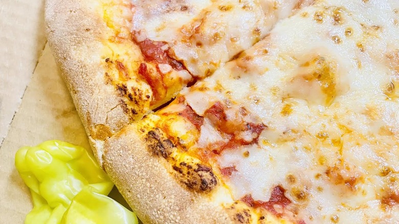 Close-up of Papa John's Stuffed Crust Pizza with pepperoncini on side