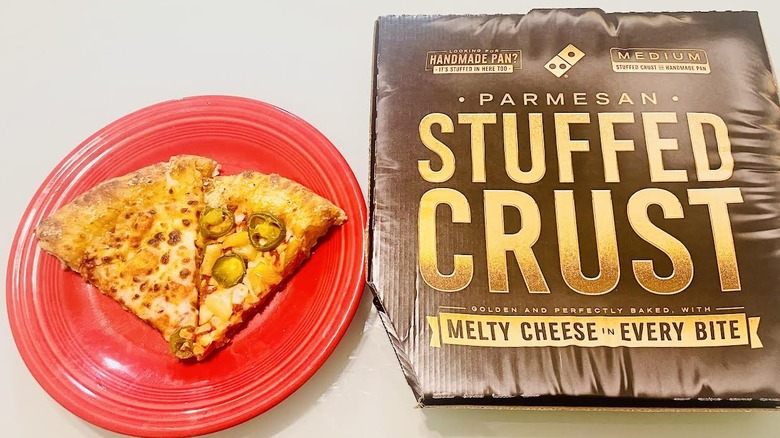Slices of Domino's Stuffed Crust Pizza on red plate with box alongside