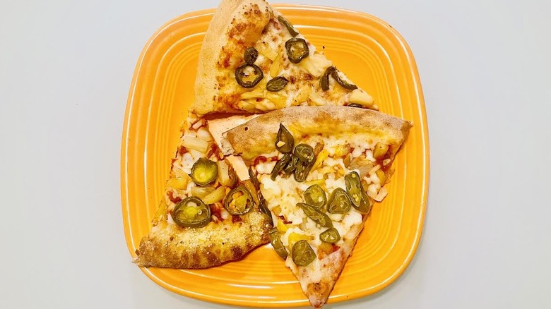 Three slices of jalapeno pineapple stuffed crust pizza on orange plate