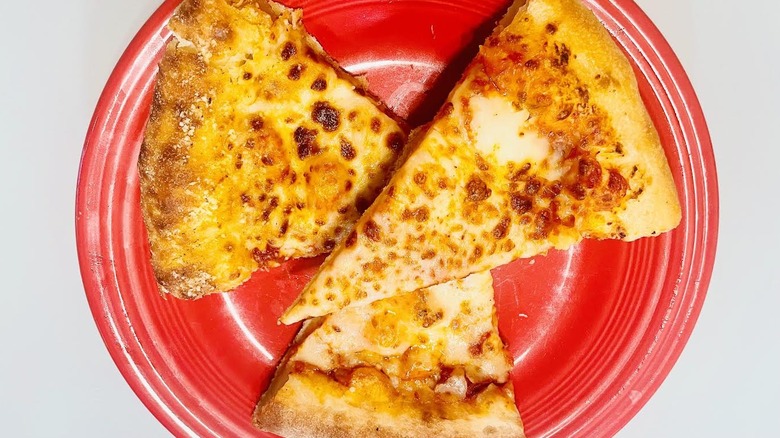Three overlapping slices of stuffed crust pizza on a red plate
