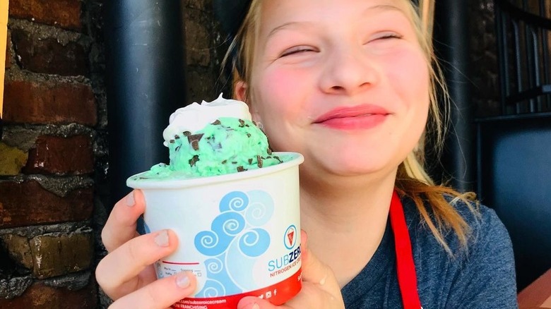Happy worker holding ice cream cup
