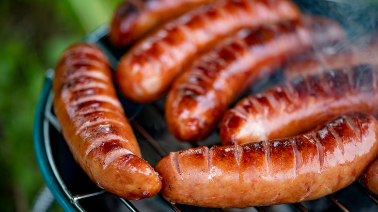Scored hot dogs on the grill