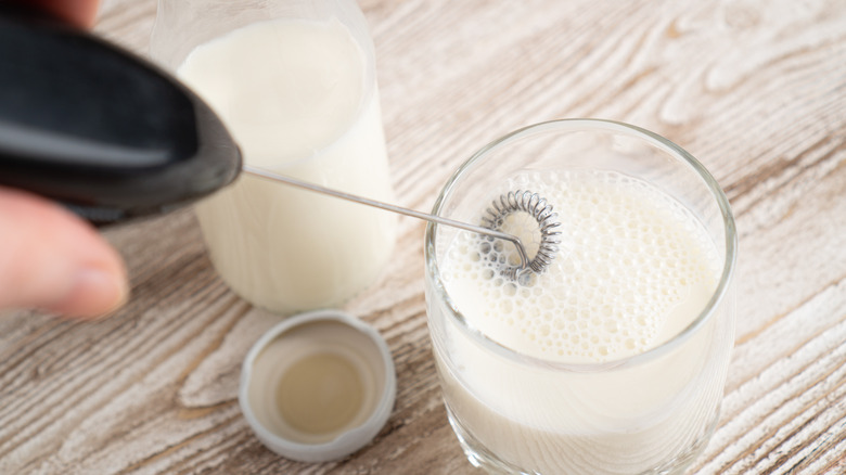 Frothing milk with milk frother by hand