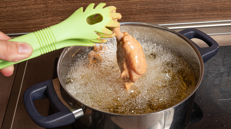 frying chicken drumsticks in pot