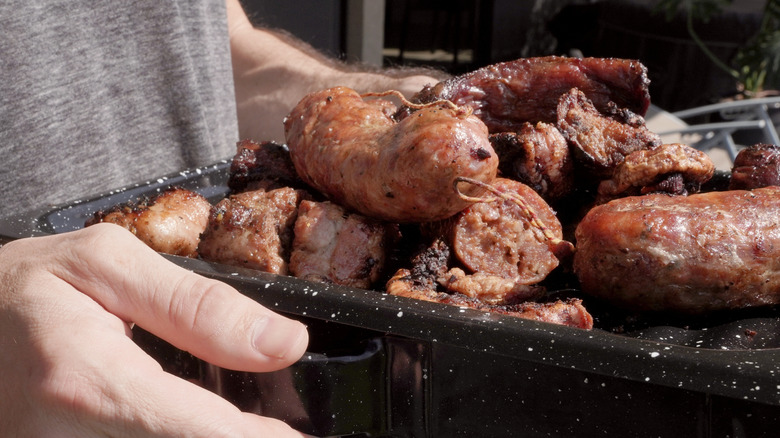 Hands holding grilled sweetbreads