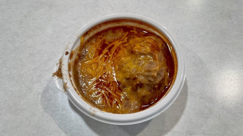 a small white dish of Taco Bell's Pintos N Cheese on a white table top