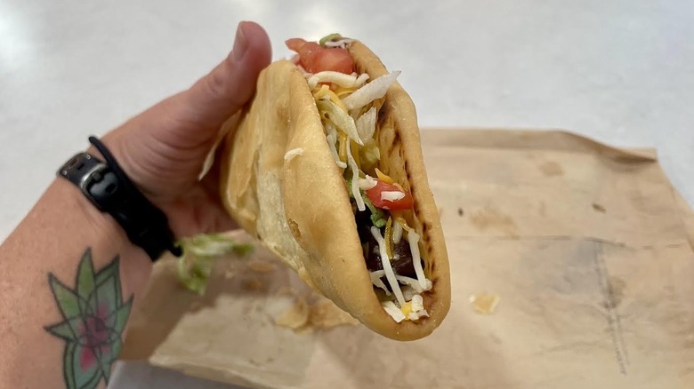 Hand holding a Taco Bell Black Bean Chalupa Supreme