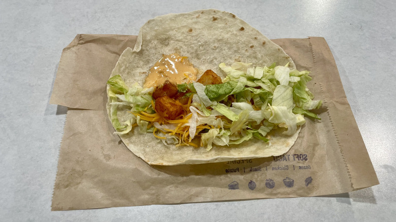 A Taco Bell Spicy Potato Soft Taco on a white table top