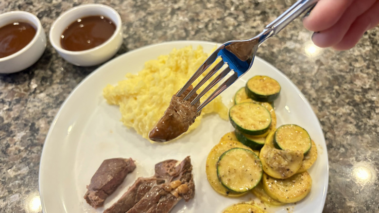 Fork with steak and sauce on it