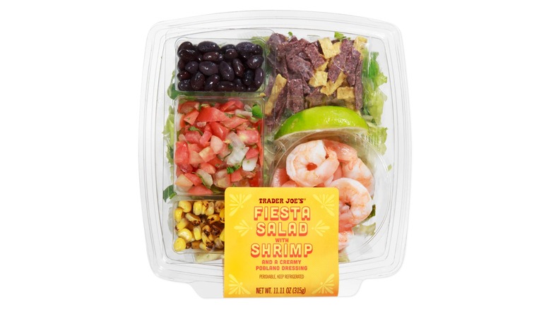 A salad from Trader Joe's is held up.
