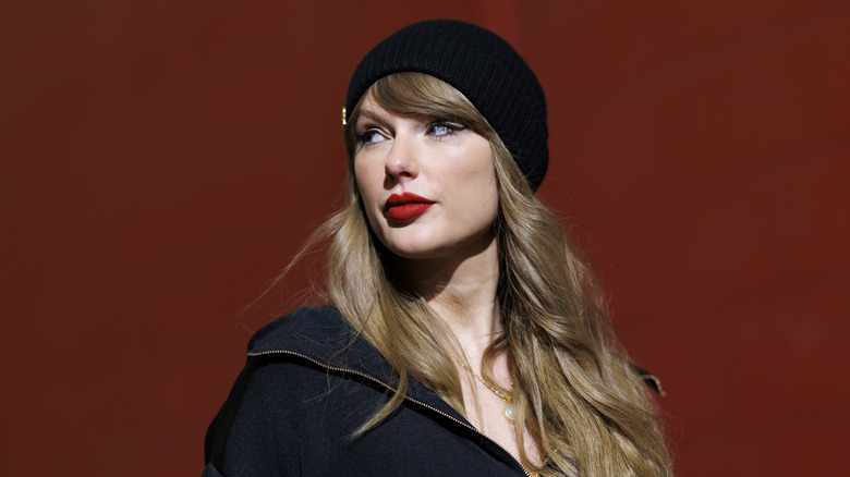 Taylor Swift posing outside of a football match