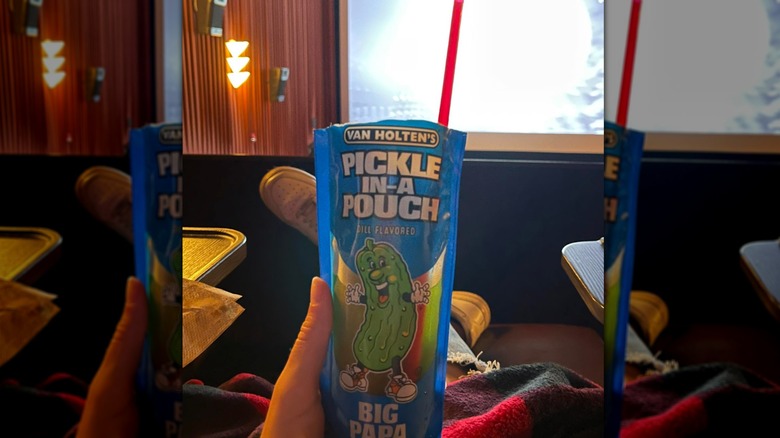 Person enjoying pickle in movie theater.