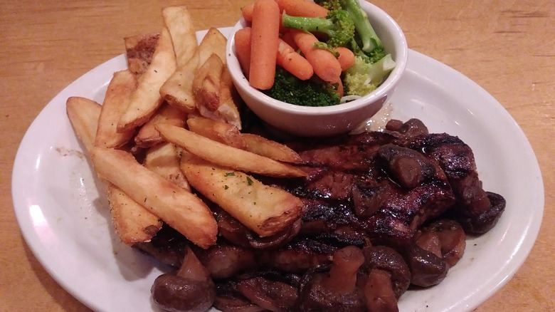 texas roadhouse steak entrée with fries and vegetables