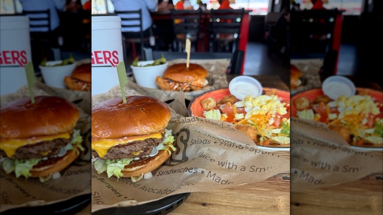 Cheeseburger, crispy chicken sandwich, and salad meals on a table at Jaggers