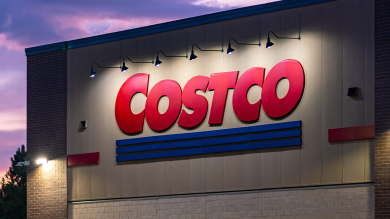Sunrise view of a Costco warehouse with the name illuminated on the wall