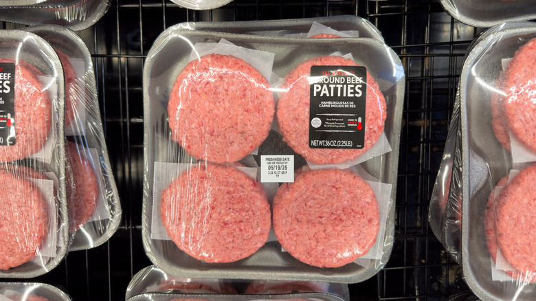Pre-formed hamburger patties in a black plastic tray