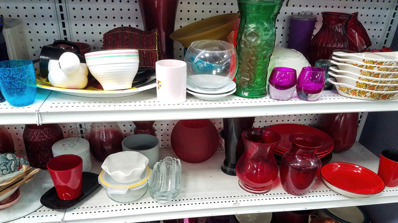 Decorative bowls, vases, and other kitchenware on thrift store shelf