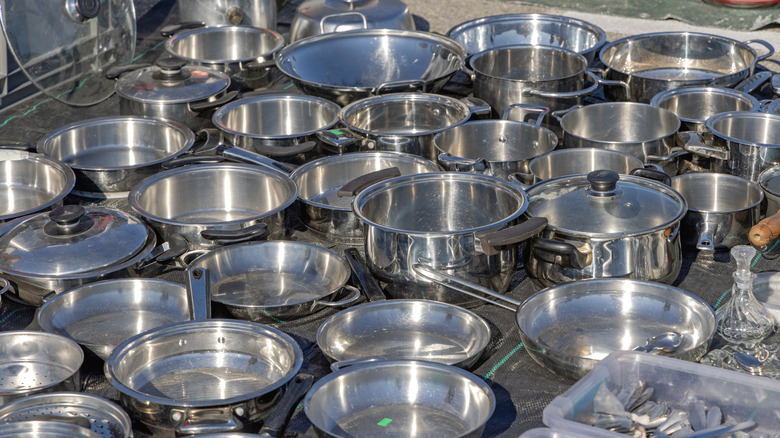 Various stainless steel pots and pans on table for sale